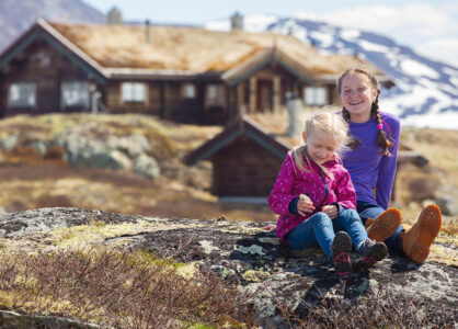 Barn foran en hytte på fjellet